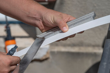 mains d'un technicien tenant une r&egrave;gle en angle &agrave; 90&deg; en  m&eacute;tal