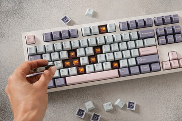 Custom build keyboard. Mechanical keyboard with colorful pastel keycaps on gray desk. Service....