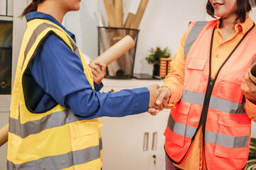 Two female architects discussing an interior design project and drawing blueprints.