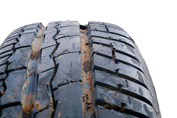 Close-up of a worn car tire showing tread damage.