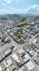 Obraz premium Aerial drone view of Phuket Old Town, Thailand, showcasing vibrant streets, colorful colonial buildings, and lively urban activity. The high-angle shot captures the charm and energy of this historic d