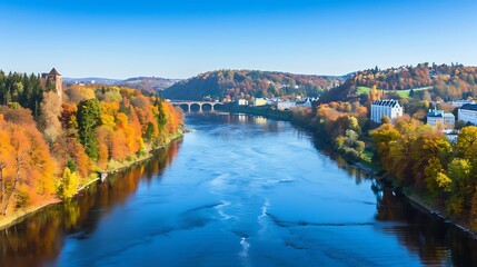 Scenic autumnal river valley view with castle and colorful foliage on a clear day