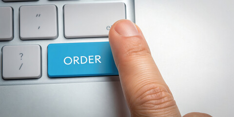 Finger pressing an "ORDER" button on a keyboard.