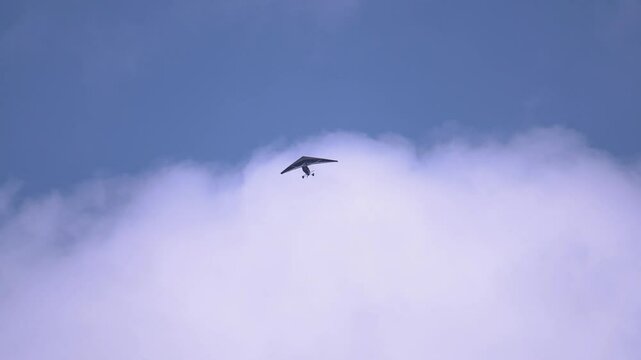 Powered paraglider flying in the clear blue sky on a sunny day