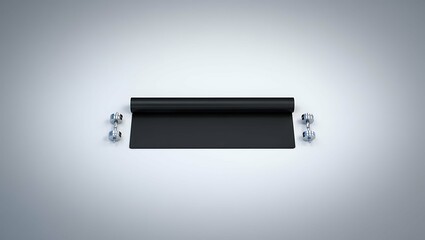 Black yoga mat unrolled with two chrome dumbbells on a clean white background
