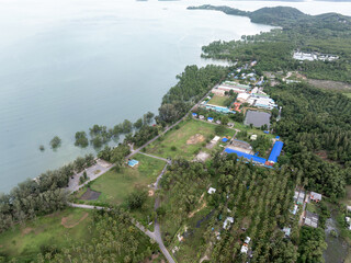 A school in Phuket, Thailand, featuring a large football field located right next to the sea. The...