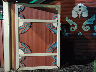 Decorative wooden door with colorful fan patterns in outdoor setting at night