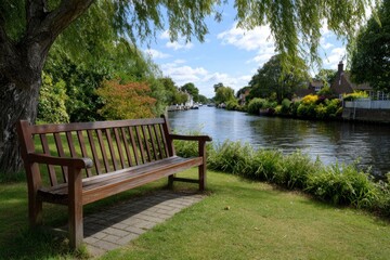 Serene scene of a wooden bench beside a calm river under a trees shade