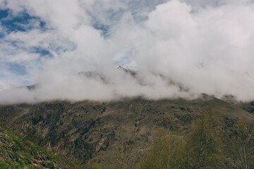 The Caucasus Mountains. The snow-covered peaks are shrouded in thick white clouds.