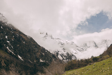 The Caucasus Mountains. The snow-covered peaks are shrouded in thick white clouds.