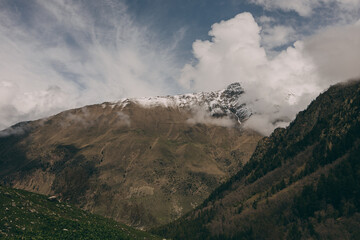 The Caucasus Mountains. The snow-covered peaks are shrouded in thick white clouds.