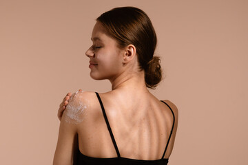 Woman Applying Skincare Product to Her Shoulder