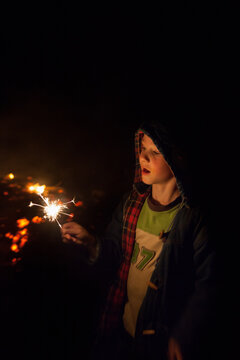 Young boy with a sparkler on a winter bonfire night