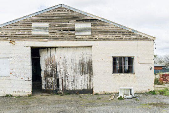 A deserted deteriorating factory building with a broken door