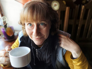 Blonde woman enjoying a warm drink while sharing her travel experiences in Hong Kong during an...