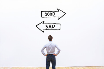 good or bad choice, business ethics concept with direction arrows on white wall