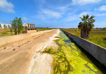 Dried-up canal with water coming from sea. No of water in river due to drought. Belcaire River in Moncofa, Spain, Castellon, Valencia. Water problem, drying up river. Canal for farm field irrigation.
