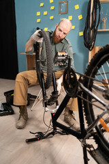 Bearded man fixing bicycle repair or maintenance at home. Bike and mechanic