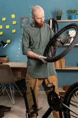 Caucasian man repairing bicycle at home. Bike workshop