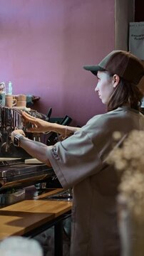 barista girl with tattoos makes coffee behind