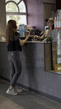 girl buys a takeaway cappuccino standing at the ba