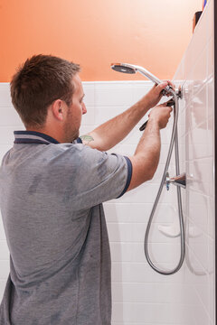 Plumber installing a shower head and tap