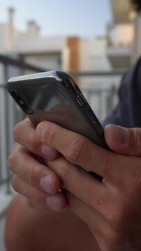 Scrolling on smartphone &ndash; vertical video. Man Hands holding smartphone and scrolling through social media app feed. Vertical 9:16 close-up of natural finger gestures, digital interaction