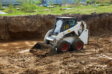 Heavy machinery moves dirt at a construction site with a clear focus on ground leveling and...