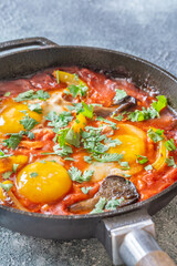 Shakshuka with mushrooms and yellow peppers topped with eggs and cilantro