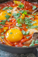 Shakshuka with mushrooms and yellow peppers topped with eggs and cilantro