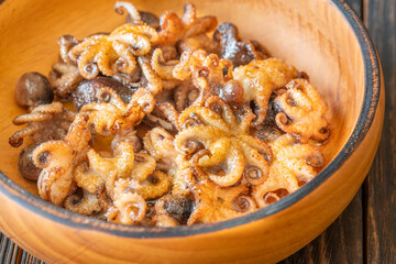 Golden Fried Garlic Octopuses Served In Rustic Wooden Bowl With Crisp Edges