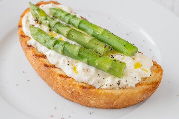 Grilled sandwich with white bread, stracciatella cheese, and green asparagus