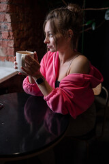 Relaxed woman smelling coffee in the morning sitting in the living room at home