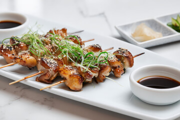 Chicken Yakitori with Sesame Seeds. Delicious chicken skewers with sesame seeds and green onions, served with soy sauce and pickled ginger, ready to eat.