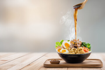 Ramen Bowl with Sauce Pouring. Delicious ramen bowl with noodles, egg, meat, and vegetables, with sauce being poured from a spoon.