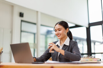 Asian business woman accounting holding coffee cup using calculating income-expenditure and...