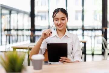 Fototapeta premium Young asian business woman manager accounting analyst checking bills, analyzing sales statistics management, taxes financial data documents or marketing report papers working in office using laptop. 