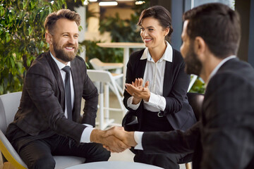 Business and partnership concept. Male corporate worker getting acquainted with new team of...