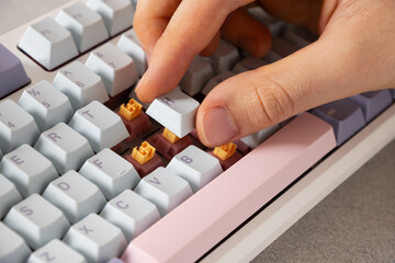 Custom build keyboard. Mechanical keyboard with colorful pastel keycaps on gray desk. Service....