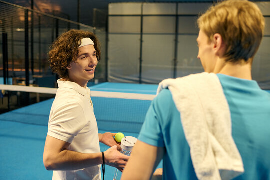 Young sportsmen enjoying a friendly moment before their padel match on the court