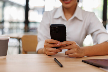 Young asian woman using phone at work desk. Using online connect technology for business, education...