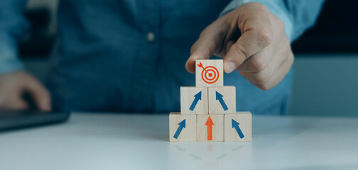 Close-up hands showing arrow growth target icons on wooden cube. Business plan strategy and increase development. Aim strategy startup business. Business Planning and goals objectives for business.