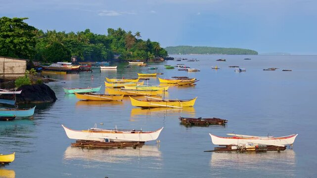 Bright traditional fishing boats anchored near the tropical coast of San Jose in Dinagat Island, Philippines.