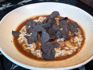 Truffle Risotto and ox tongue, a dish that combine the luxurious flavor of truffle with the rich...