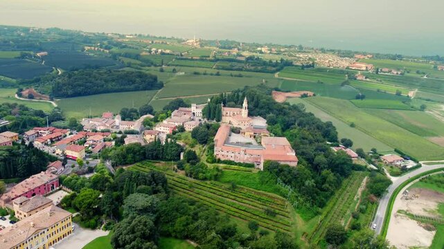 Aerial view of Col&agrave; di Lazise, a peaceful Italian village near Lake Garda, surrounded by vineyards, historic buildings, and rolling countryside in the Verona wine region.