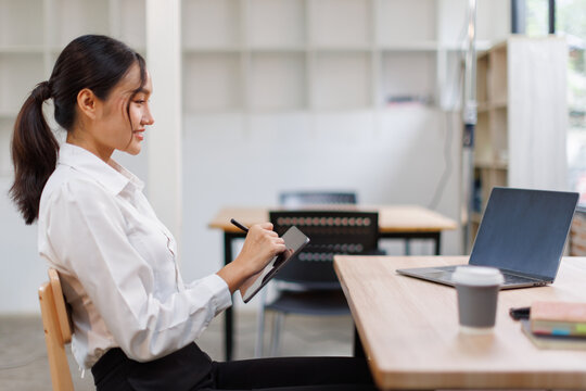 Asian Business woman using calculator and tablet laptop for doing math finance on an office desk, tax, report, accounting, statistics, and analytical research concept
