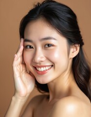 Fototapeta premium Happy Asian woman face smiling on brown studio background. Beautiful Japanese female model smiling for skincare, cosmetic, beauty. Portrait of young person showing healthy skin, perfect smile.
