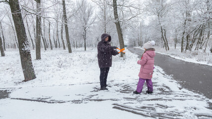 Grandmother playing with granddaughters at park in winter