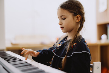 Young Girl Playing Keyboard Piano Indoors