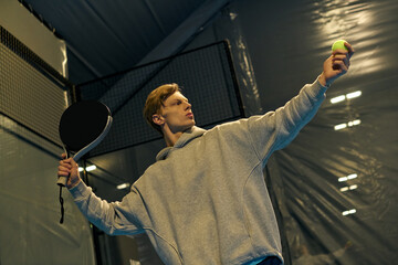 Young athlete showcases skill during intense padel match on indoor court